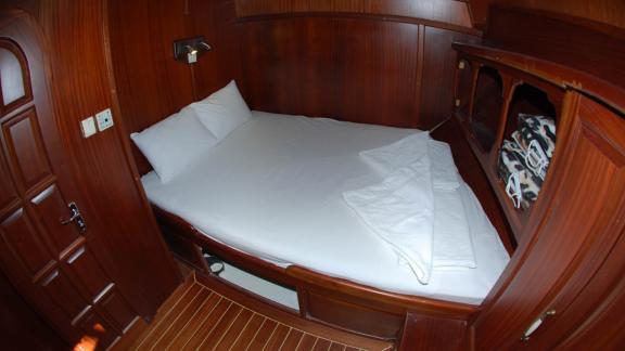 A cosy sleeping berth on the Sahinoğlu gulet, with a comfortable double bed and practical storage compartments in the wo